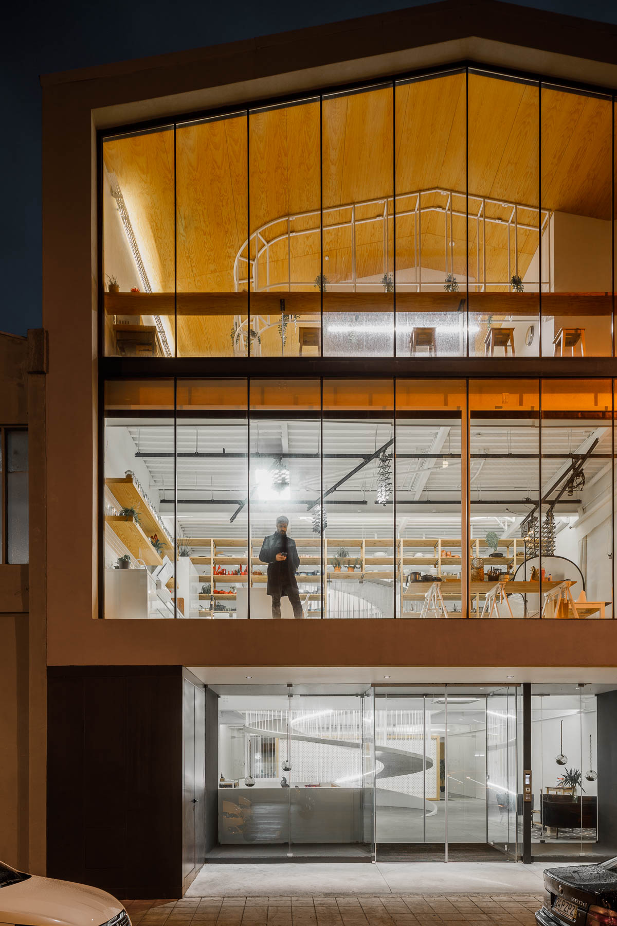 The exterior of this modern office has walls of glass providing a glimpse of the interior for the pedestrians on the street.