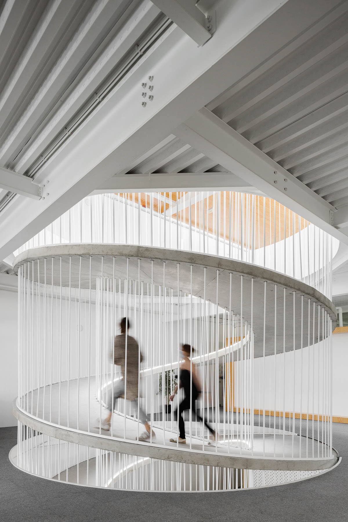 A spiraling ramp replaces the need for stairs in this modern office and adds a sculptural element.