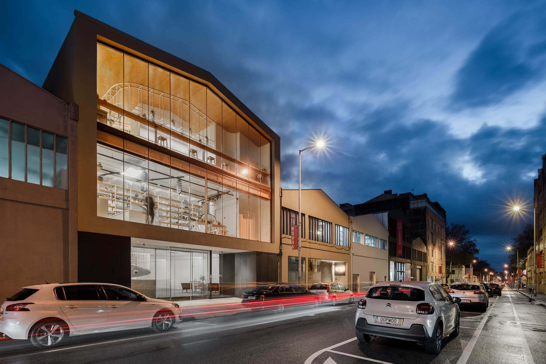 The exterior of this modern office has walls of glass providing a glimpse of the interior for the pedestrians on the street.