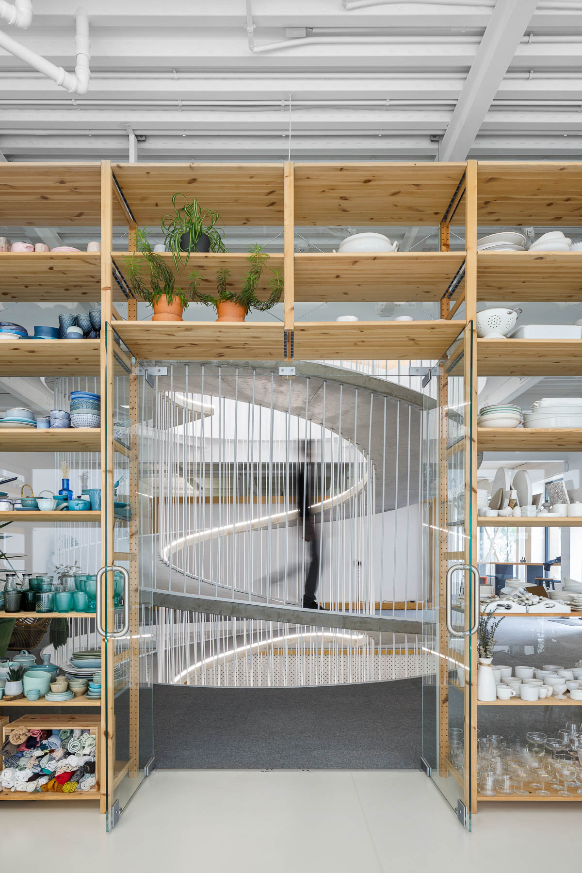 Wood shelves frame a spiraling ramp in the center of this modern office.