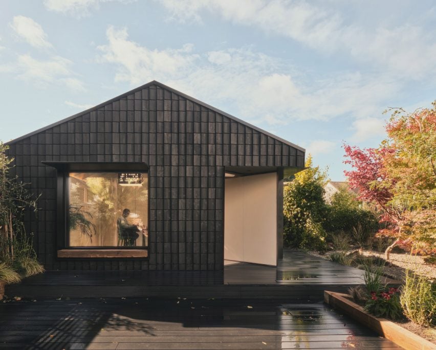 Dark Matter garden studio by Hyperspace features pivoting door