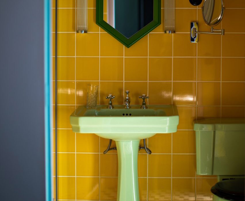 Eight bathrooms with colourful toilets and sinks