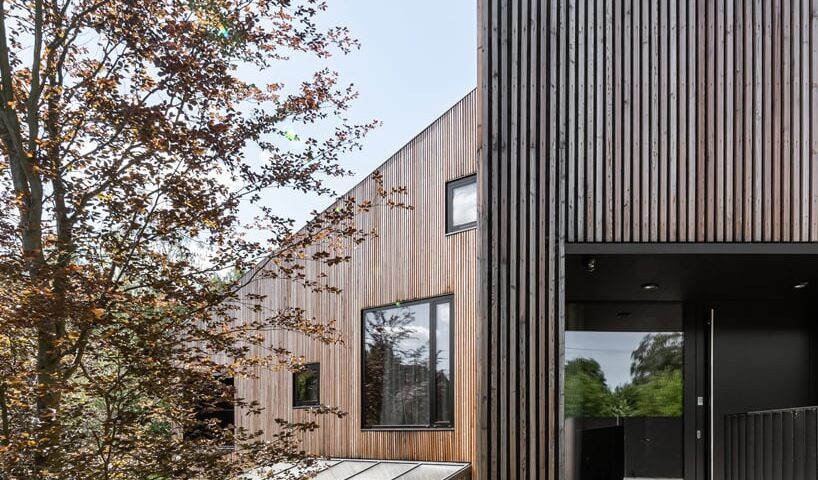 fragmented residence wraps in raw larch slats on narrow sloping plot in poland