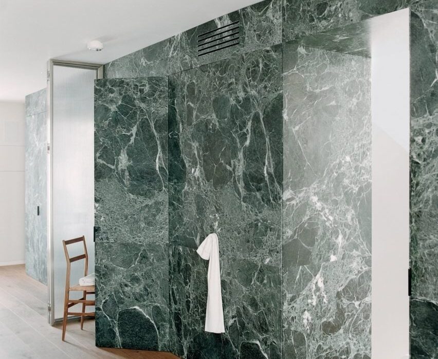 Monolithic green marble carves apartment interior in Milan by AIM Studio