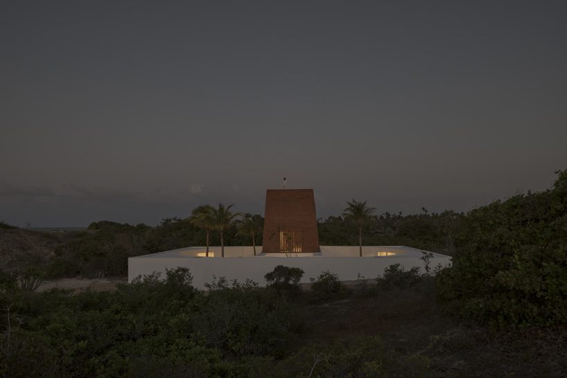 a brick tower rises from a concrete base inside matteo arnone’s caso attico